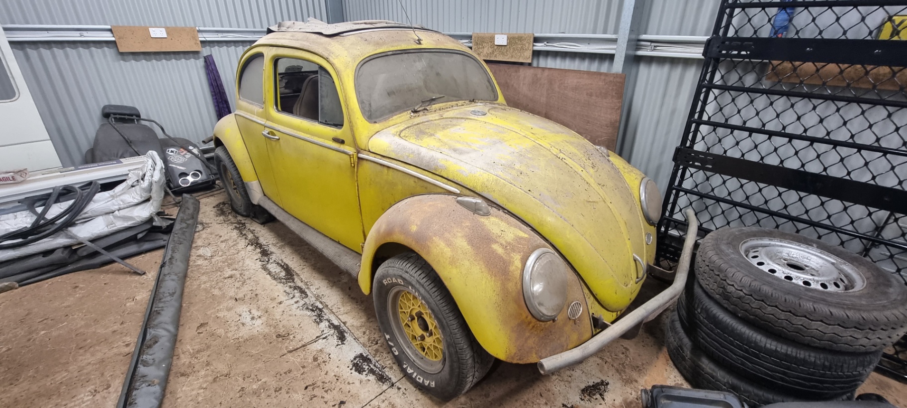 1956 Volkswagen Beetle with oval rear window, side view in a garage